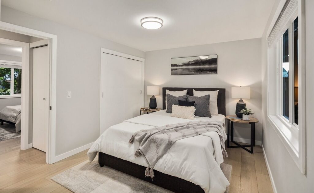 Bedroom with layered bedding and warm bedside lamps in a staged Kirkland home