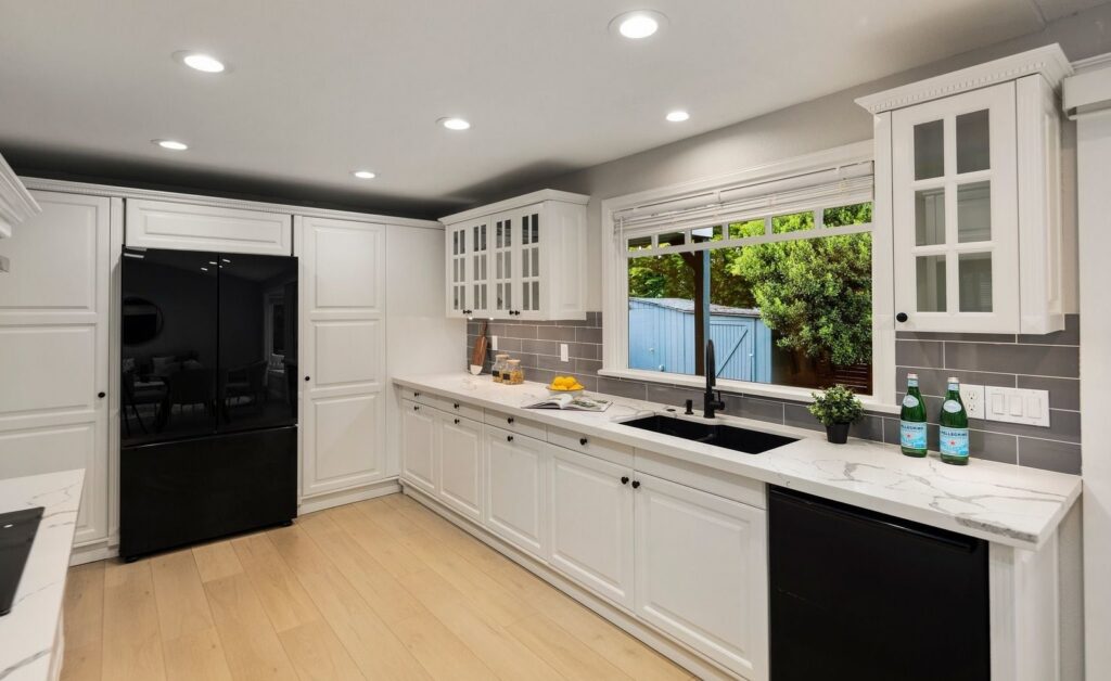Kitchen with white cabinets and a window over the sink