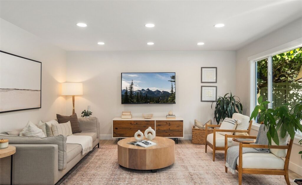 Family room with a round coffee table, lounge chairs and a media console