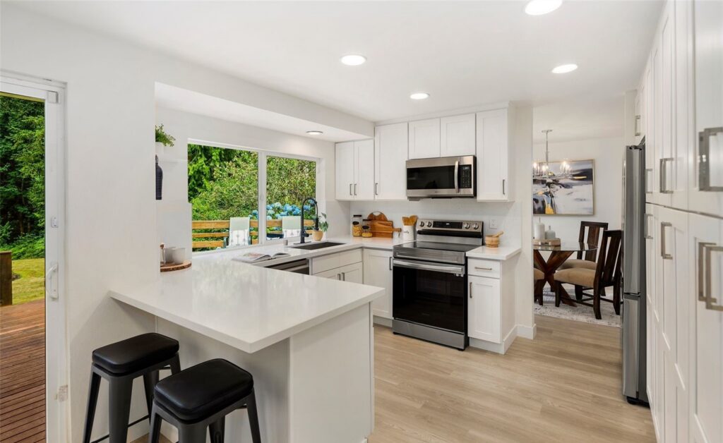 Kitchen with white cabinets and a breakfast area by the window