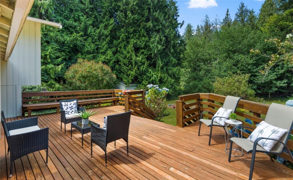 Deck with outdoor seating surrounded by evergreen trees