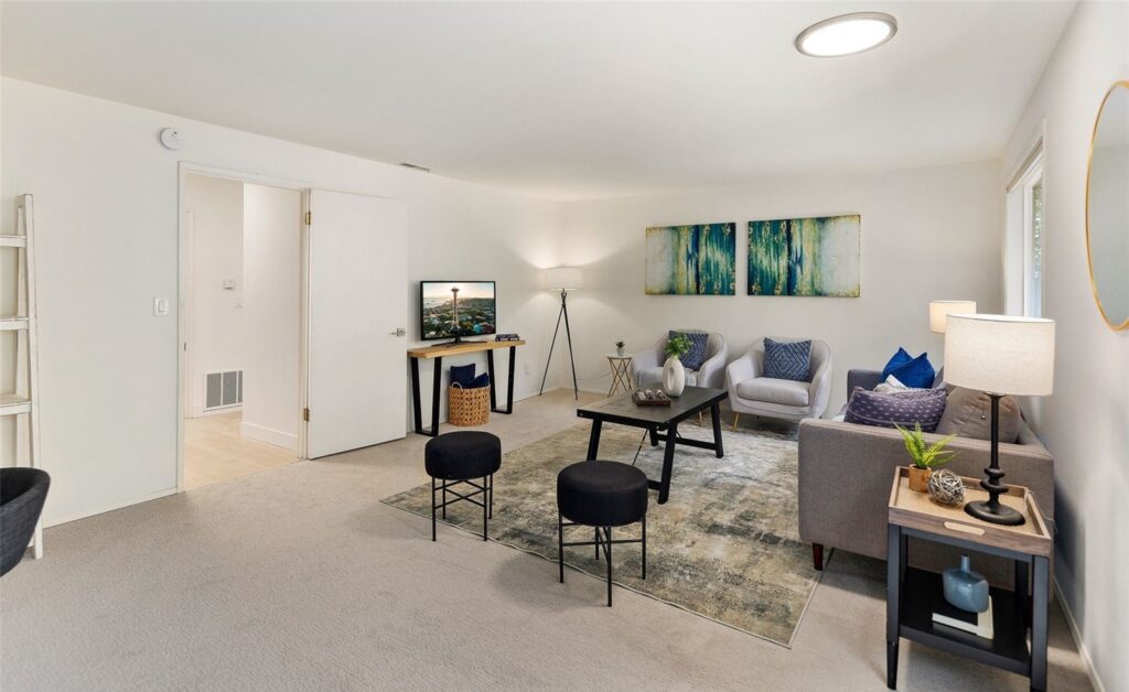Family room staged with a sofa, accent chairs and a media console in a Sammamish home