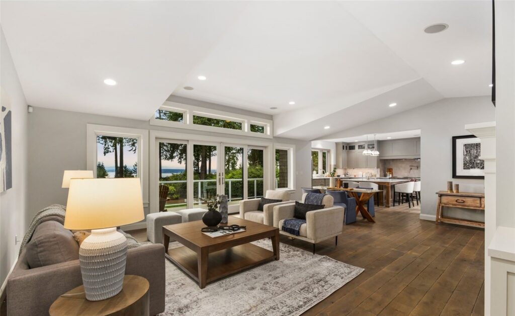 Seattle home staging in a contemporary living room with a wall of windows, light sofas and lounge chairs