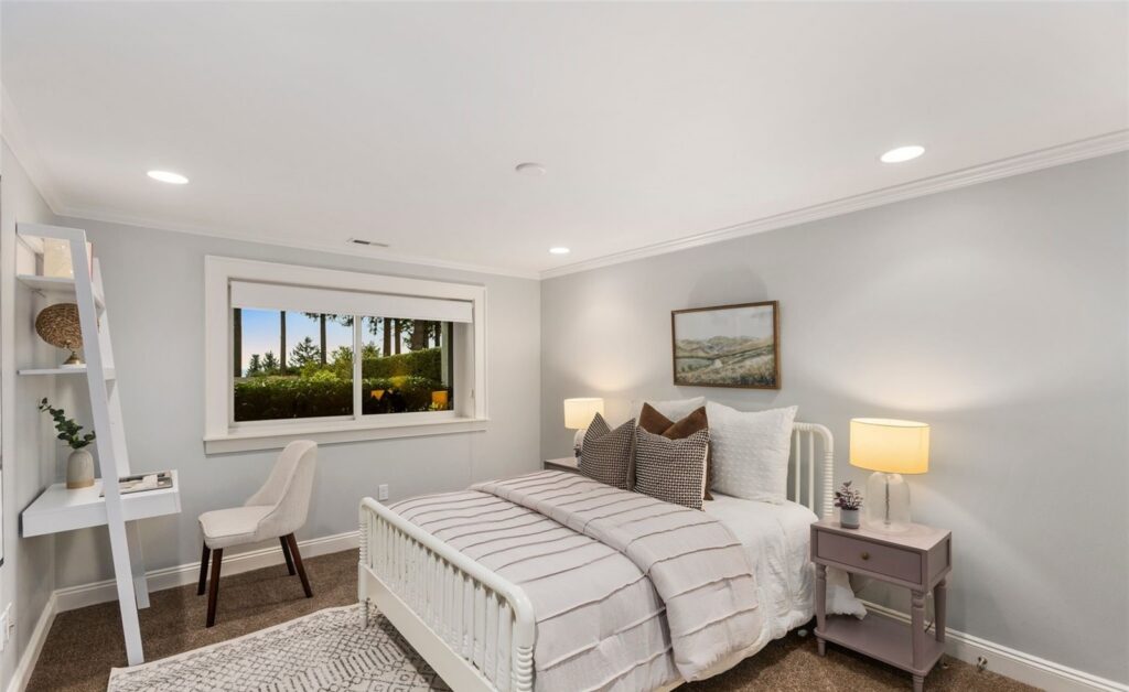 Bedroom with layered bedding, bedside lamps and a wide garden window